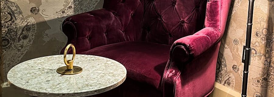 A Purple Armchair Near the Lamp and Marble Table