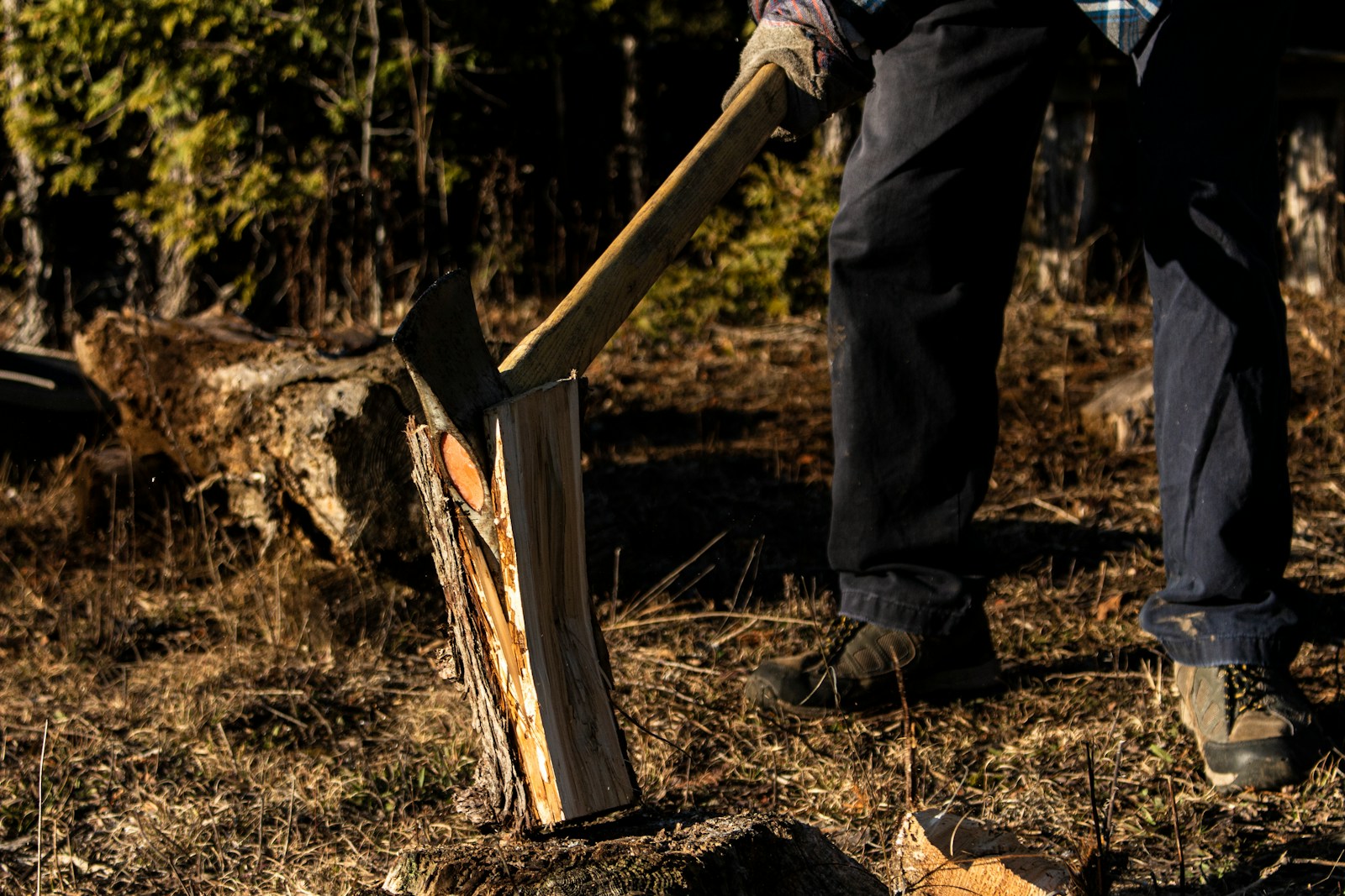 person in black jacket and pants holding brown wooden stick